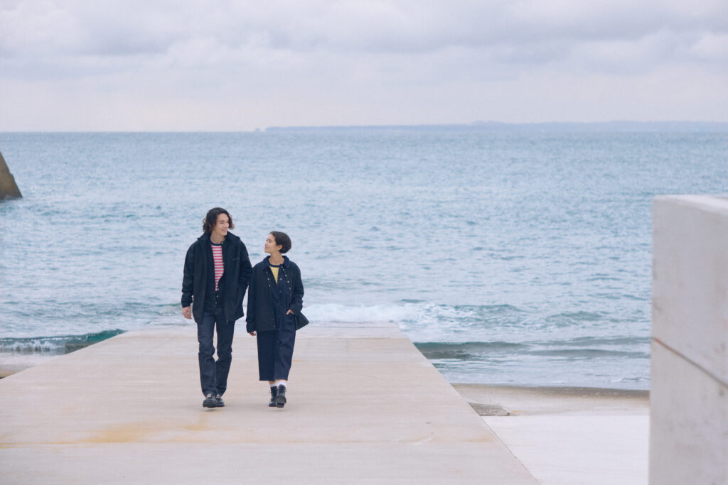男性と女性が海をバックに歩いている写真